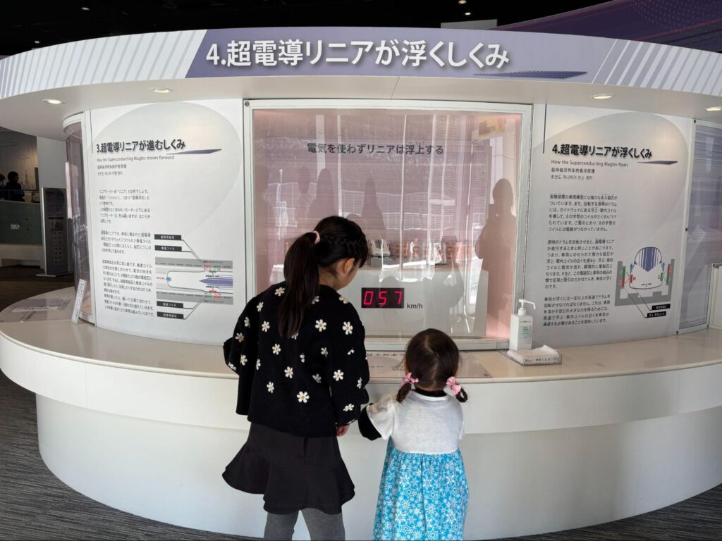 山梨県立リニア見学センターで「超電導リニアが浮くしくみ」の展示を見学する子どもたち 