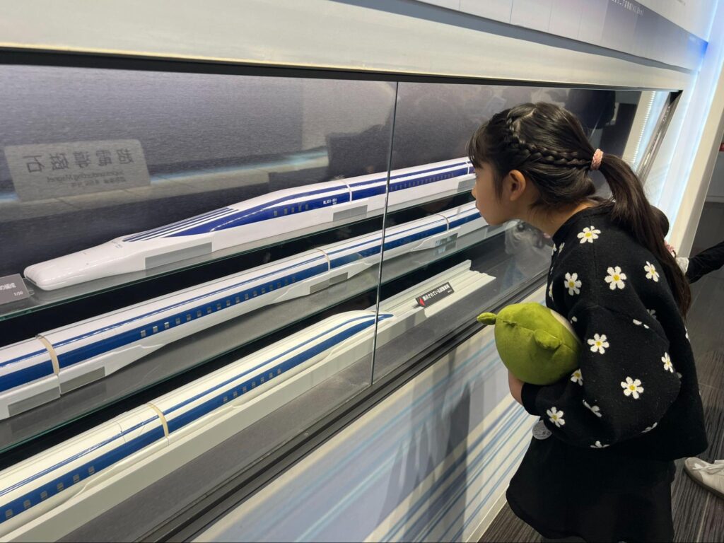 山梨県立リニア見学センターでリニアの模型展示を見学する子ども 