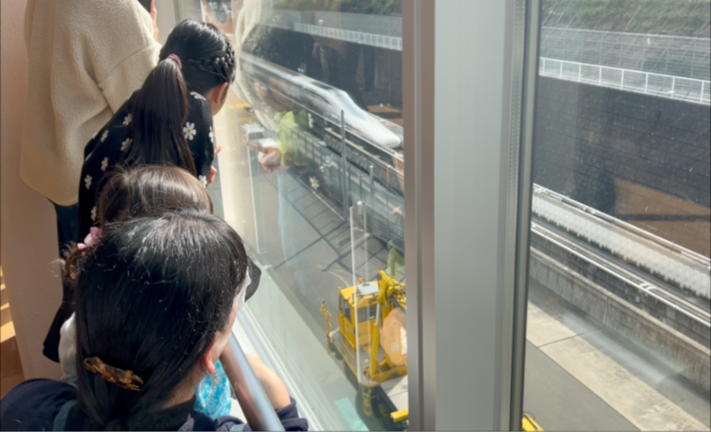 山梨県立リニア見学センターの展望フロアからリニア走行試験を見学する子どもたち 