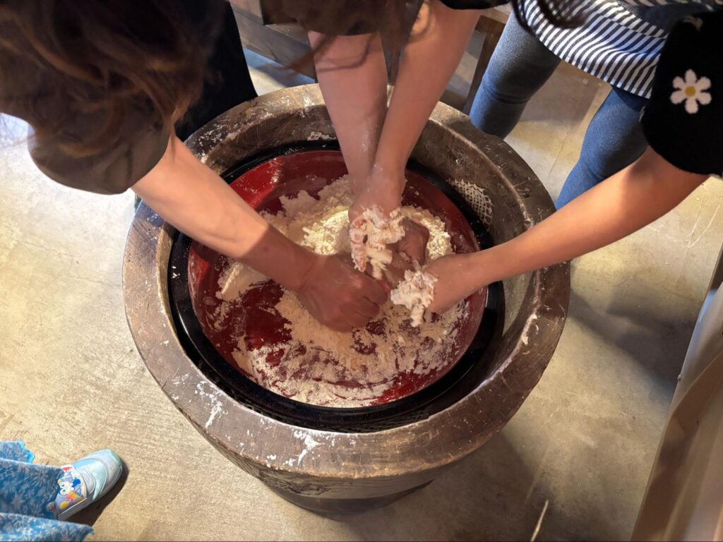 都留市ぽっぽやでのほうとうづくり体験で生地をこねる様子 