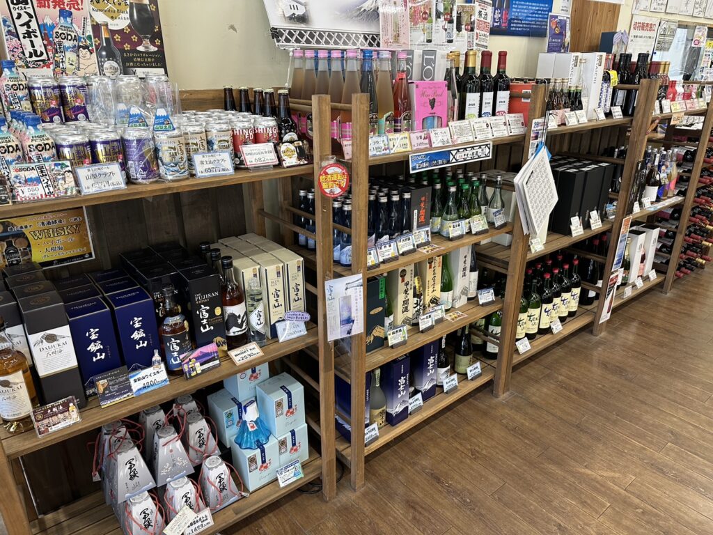 山梨県都留市「道の駅つる」に並ぶ山梨ワインや地酒の販売棚