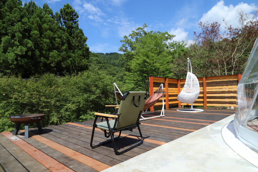 森に囲まれたウッドデッキでくつろげるTHE FORESTの滞在スペース